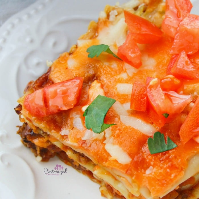 Easy taco lasagna all dressed up with fresh cilantro and diced tomatoes