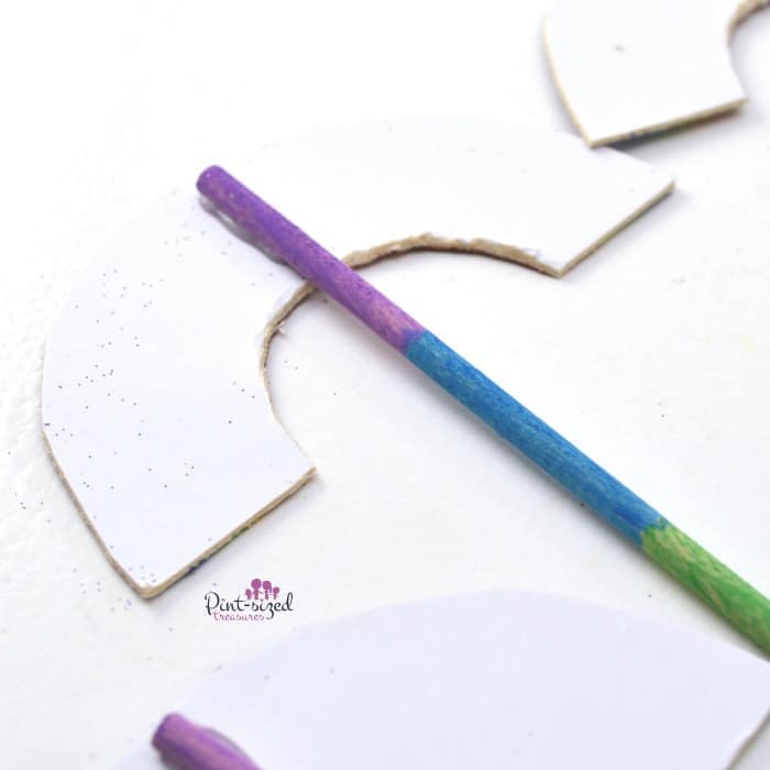 attaching the wand to the paper rainbow