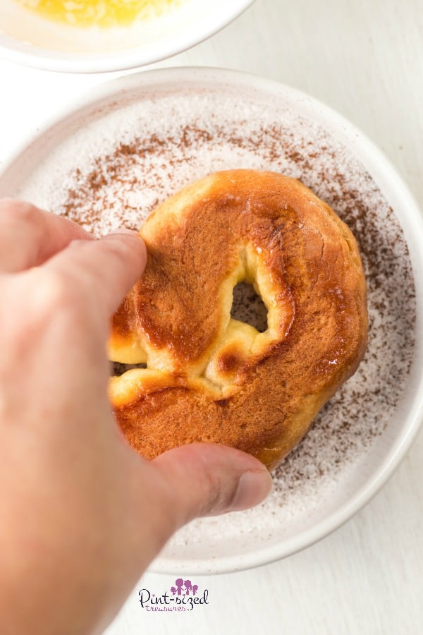 dipping soft pretzels in cinnamon sugar