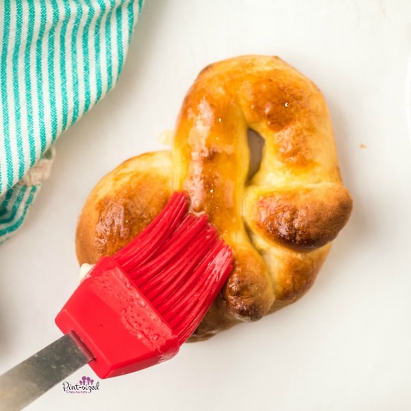 spreading butter on baked soft pretzels