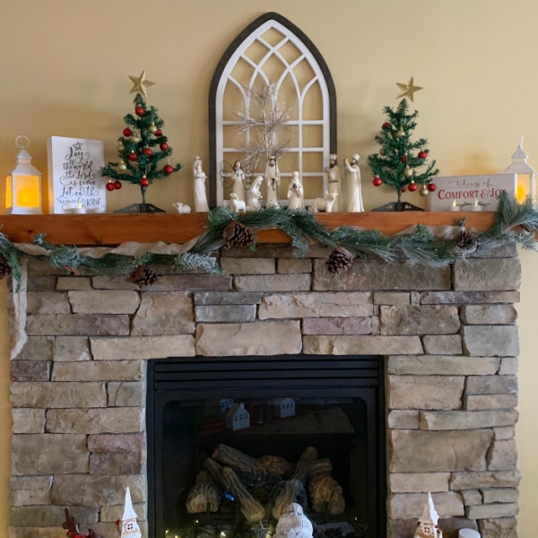 mantel with garland before cleaning and organizing