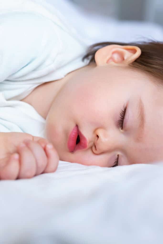 toddler sleeping on bed