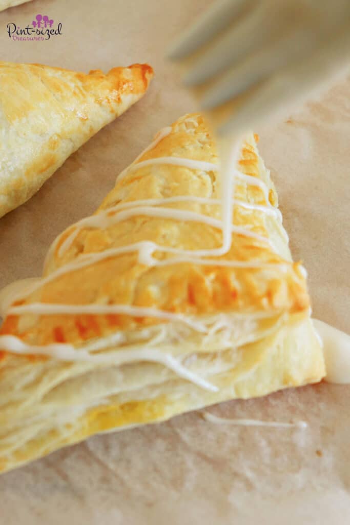 drizzling vanilla glaze on apple turnovers