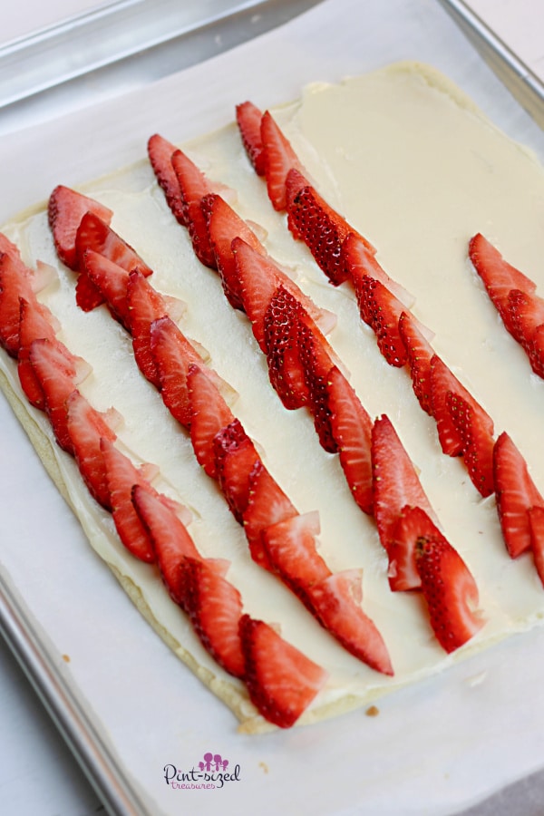adding strawberries to patriotic fruit pizza