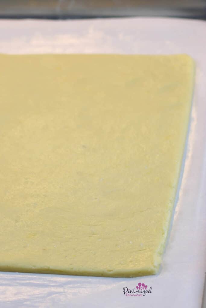 rolling out sugar cookie dough for fruit pizza