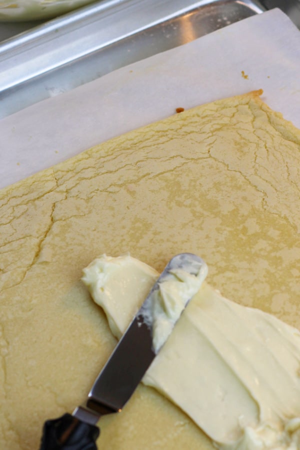 spreading mixture on top of sugar cookie crust for American flag fruit pizza