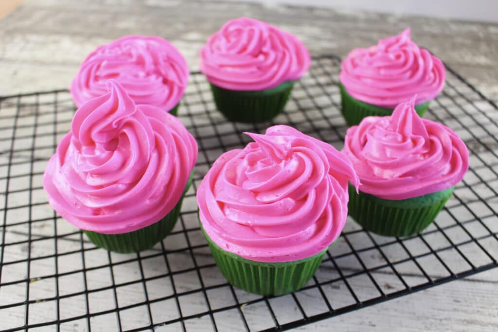 frosted watermelon cupcakes on cooling rack