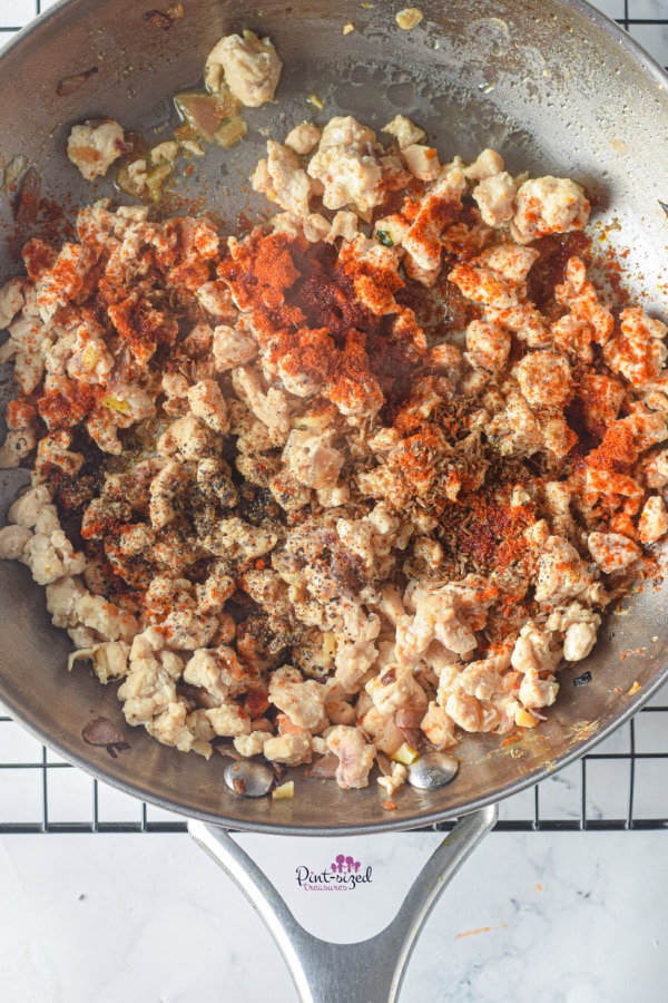 adding spices to chicken for stuffed peppers recipe