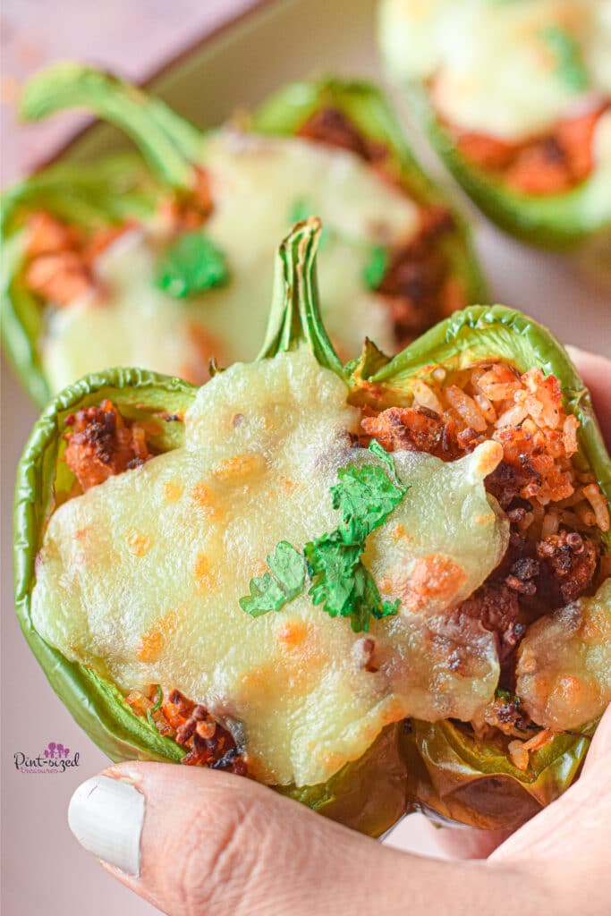 holding one of the stuffed peppers