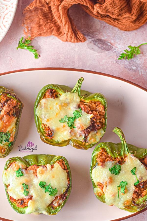 four stuffed peppers on a serving plate