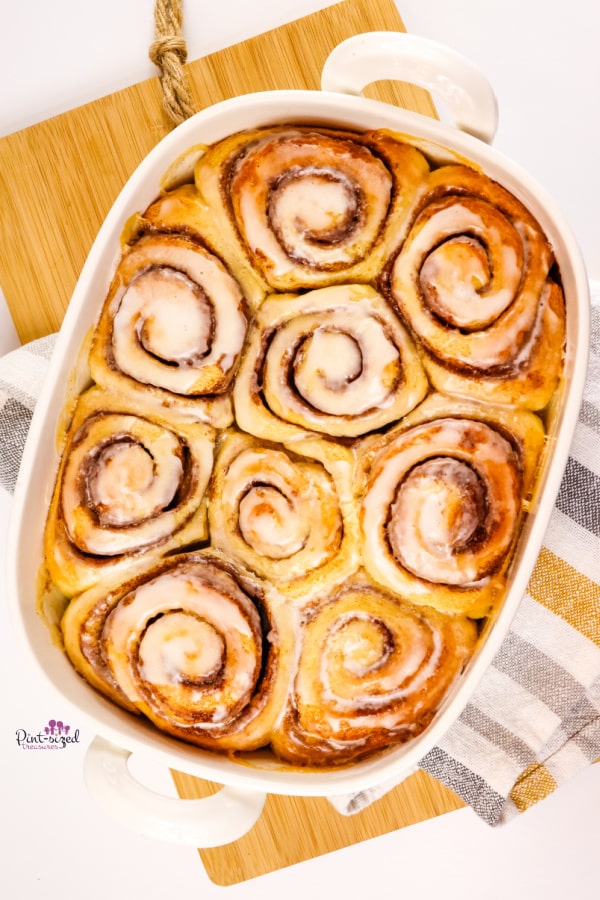 cinnamon rolls with glaze in white baking dish
