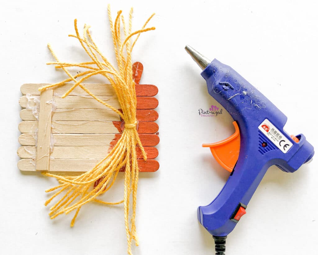 adding yarn to popsicle scarecrow craft