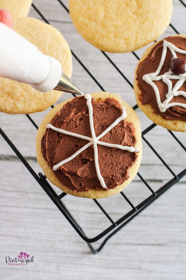 piping webs onto spider cookies