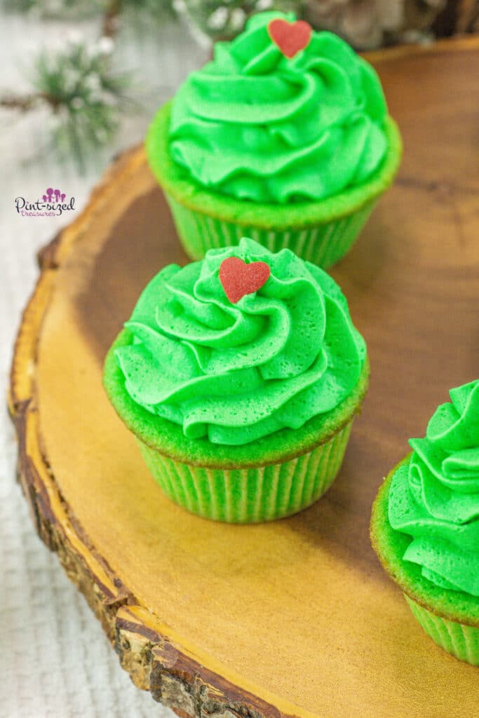 grinch cupcakes sitting on wood slice